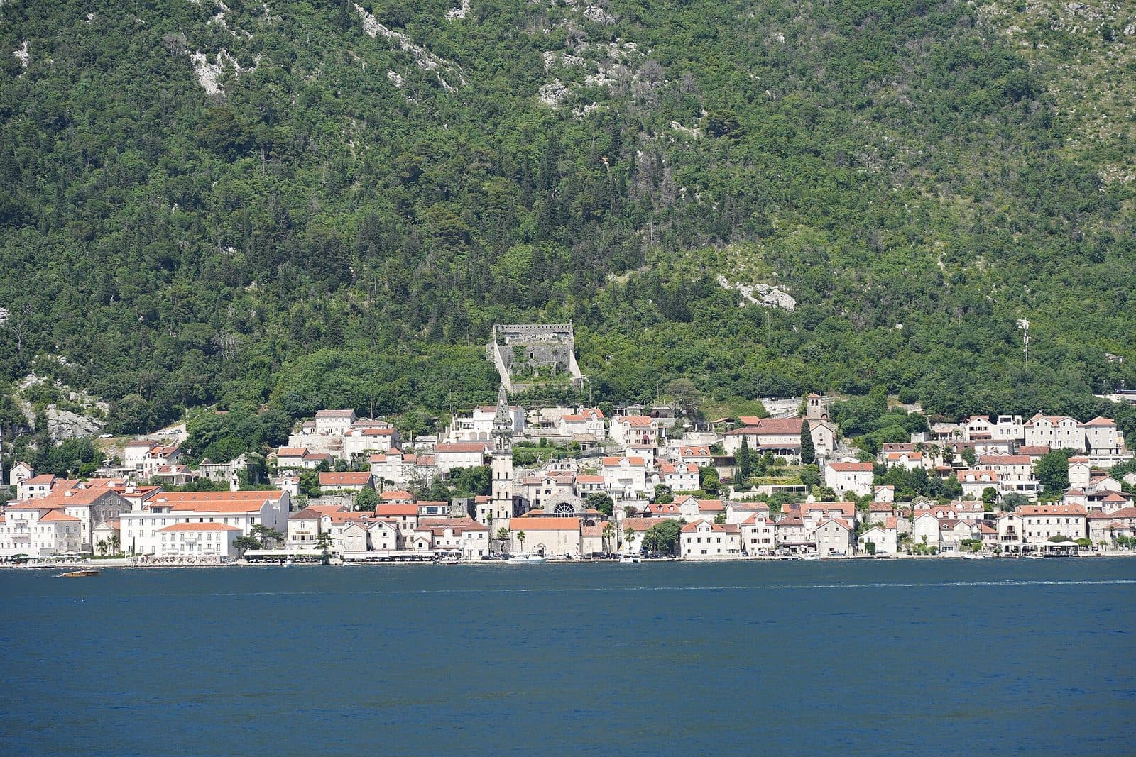 The waterfront town of Perast beneath wooded hills on the Bay of Kotor, Montenegro